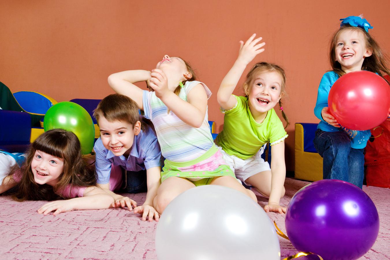 Happy preschool kids playing with balloons