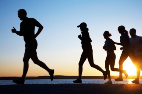 group of young people runs at the beach on beautiful summer sunset